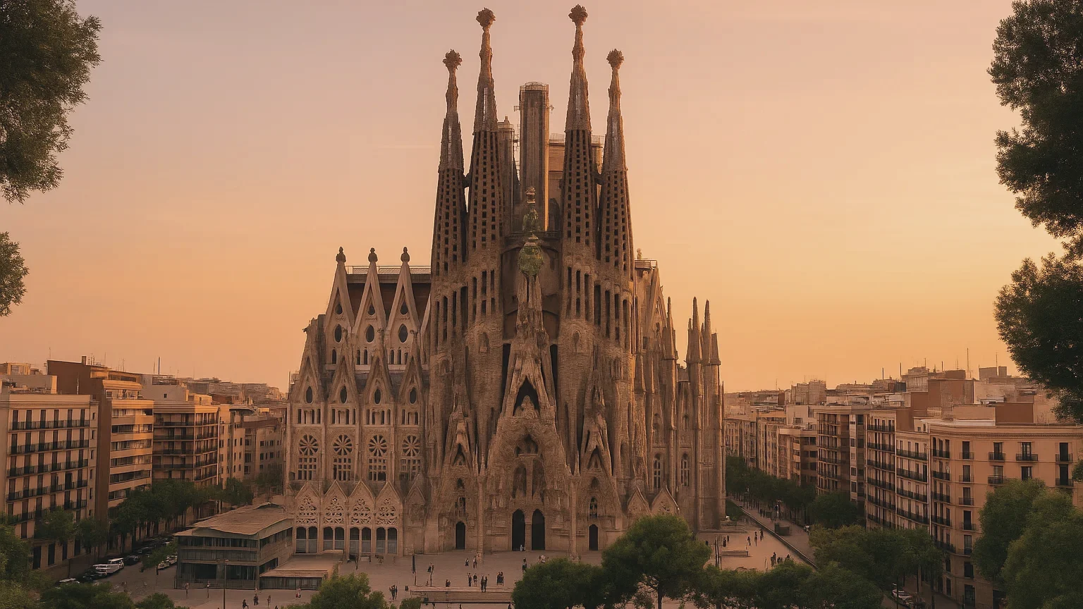 The whole Sagrada Família basilica, lit gold at sunset above the Eixample