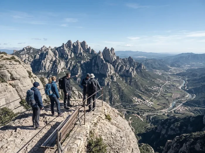 Walkers on a trail in Montserrat Natural Park below the rock pinnacles