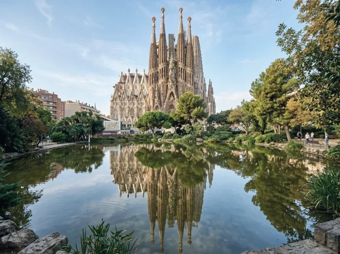 The Sagrada Família reflected in a pond among trees