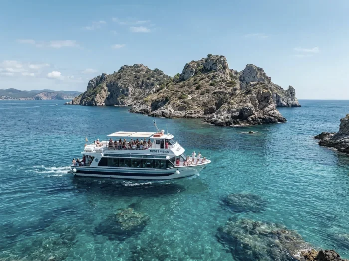 A tour boat near small rocky islands in turquoise water