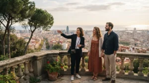 A guide points out the Barcelona skyline to a couple holding hands on a stone balustrade terrace at golden hour