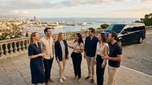 Six adult friends with their guide on a Montjuic viewpoint terrace above the Barcelona port, a dark van parked behind